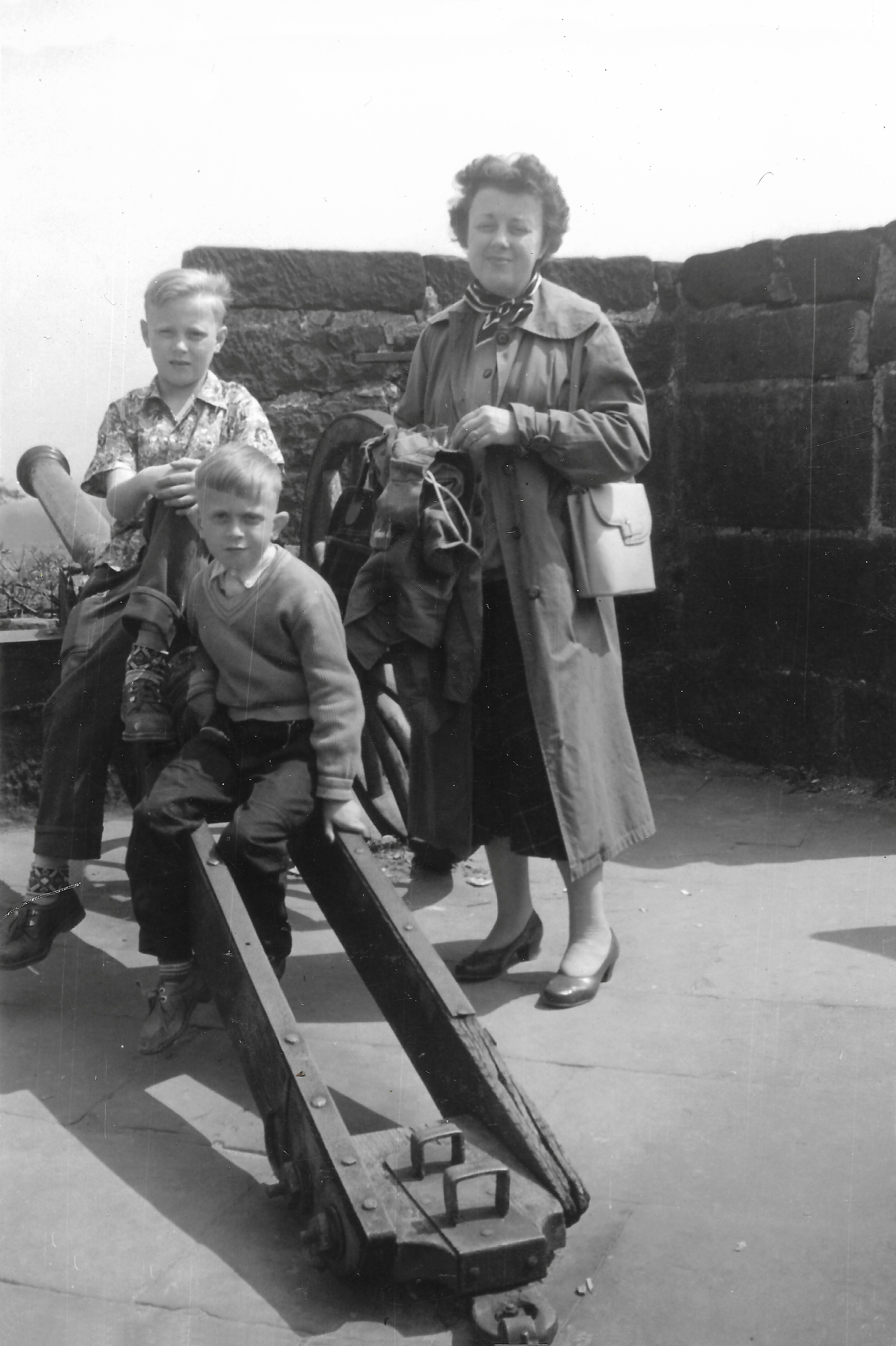 Zwart-wit jeugdfoto uit het familiealbum: twee jongens, onder wie Ed van Peppen, op een oud kanon naast hun moeder.