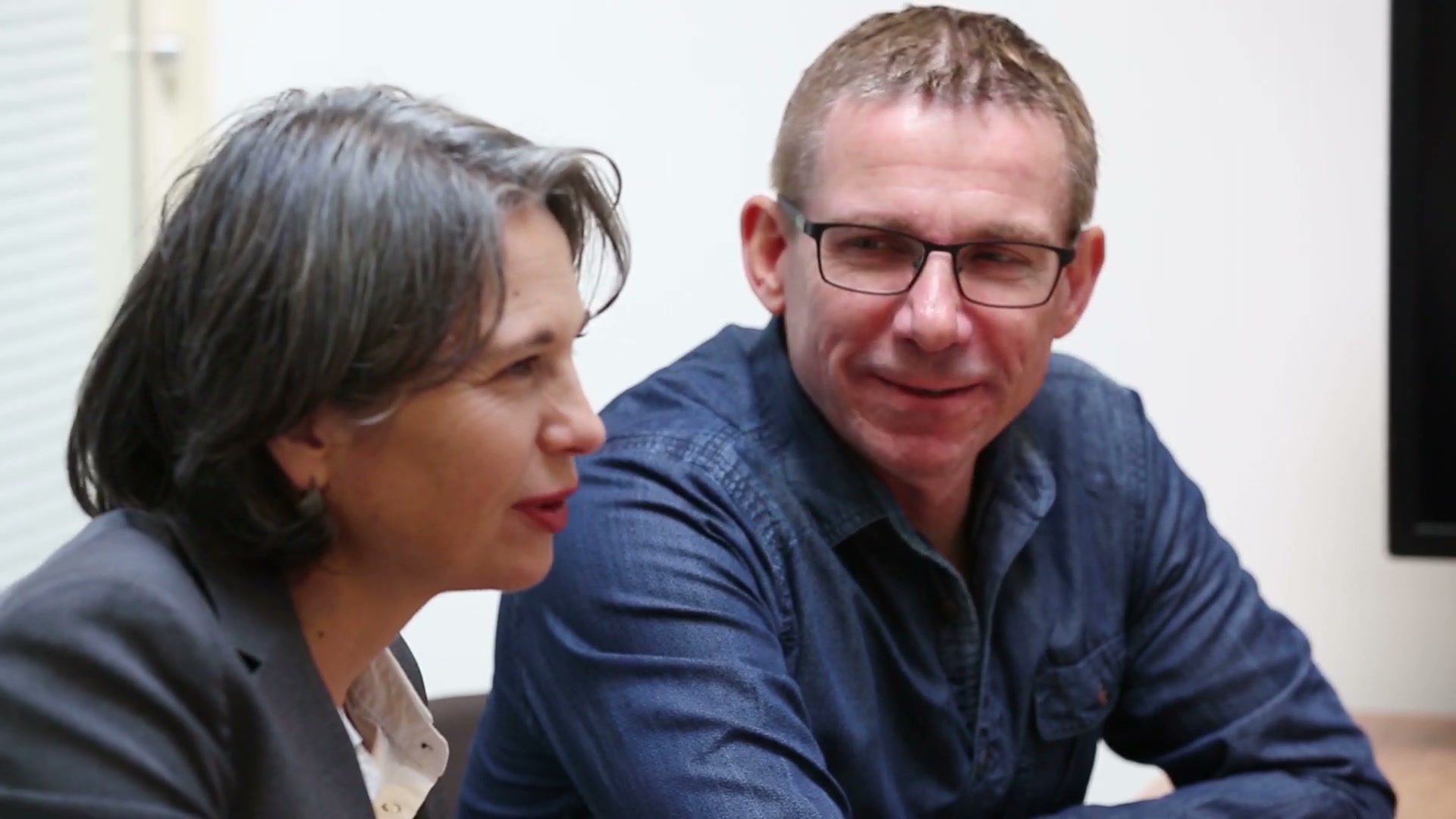Een man en een vrouw aan tafel in een adviesgesprek bij Van Peppen; de man glimlacht.